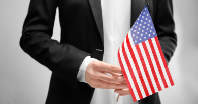 Person in suit holding American flag
