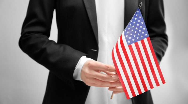 Person in suit holding American flag