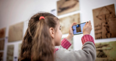 Young girl using a phone to explore a museum