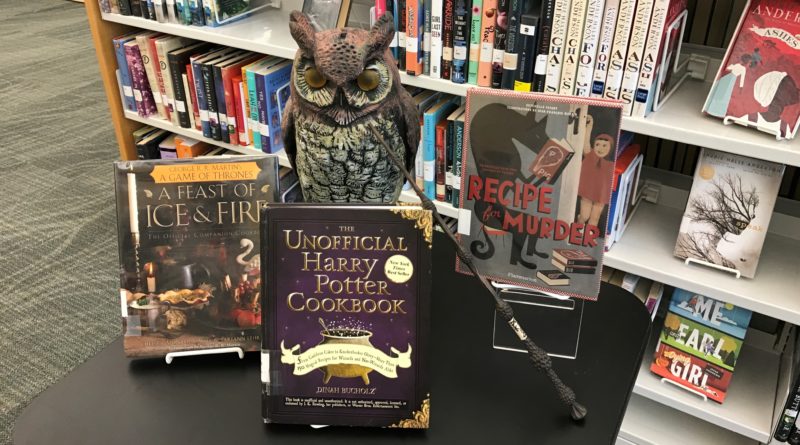 Book display showing literature themed cook books, a wand and owl