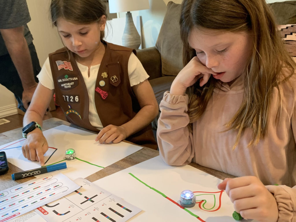 two girl scouts use ozobot robots